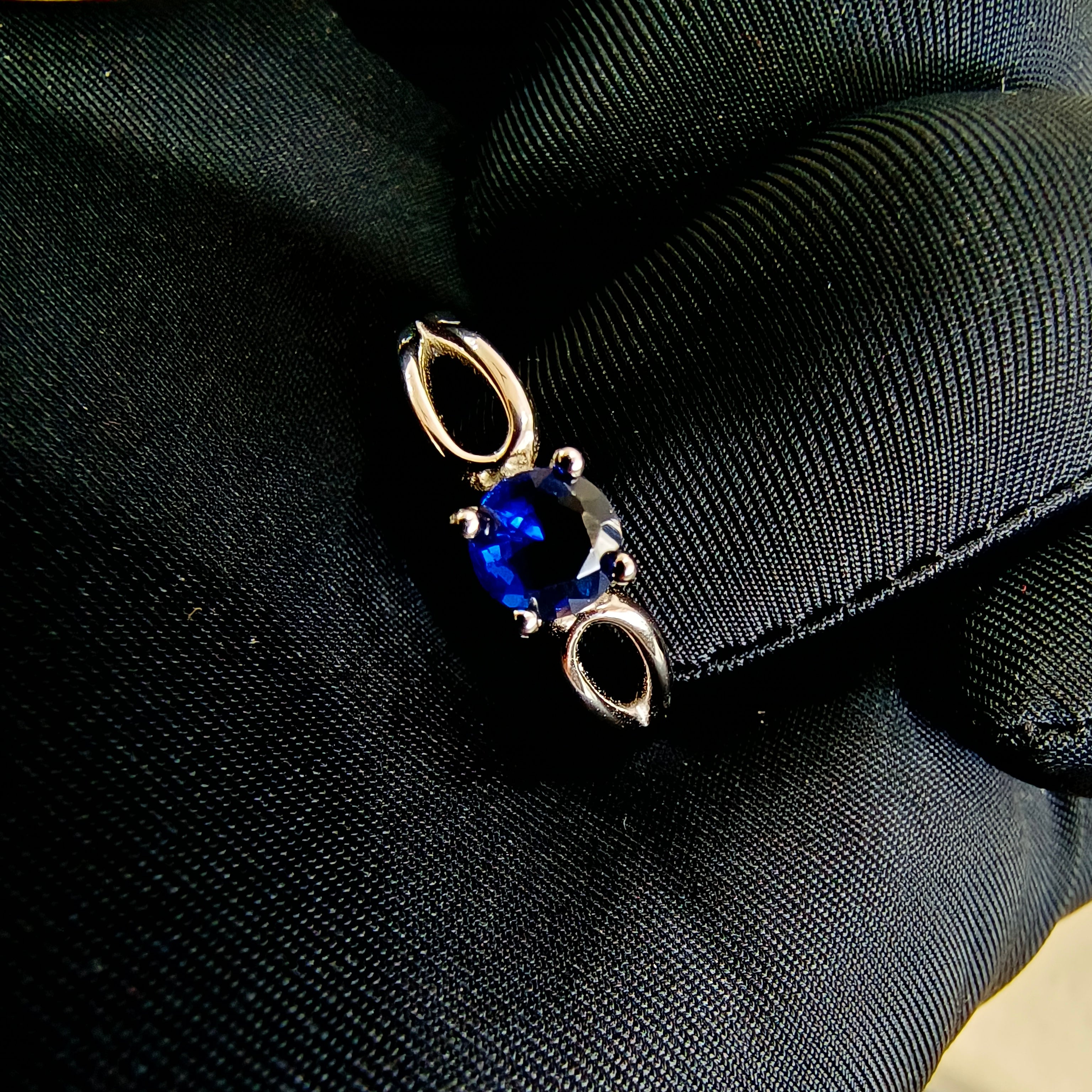 a blue ring sitting on top of a black piece of luggage