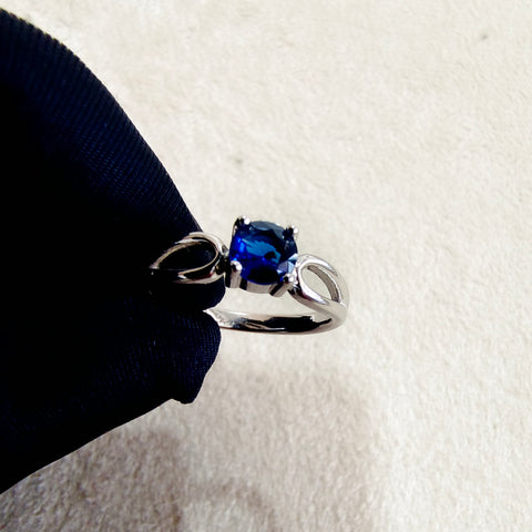 a blue ring sitting on top of a black cloth