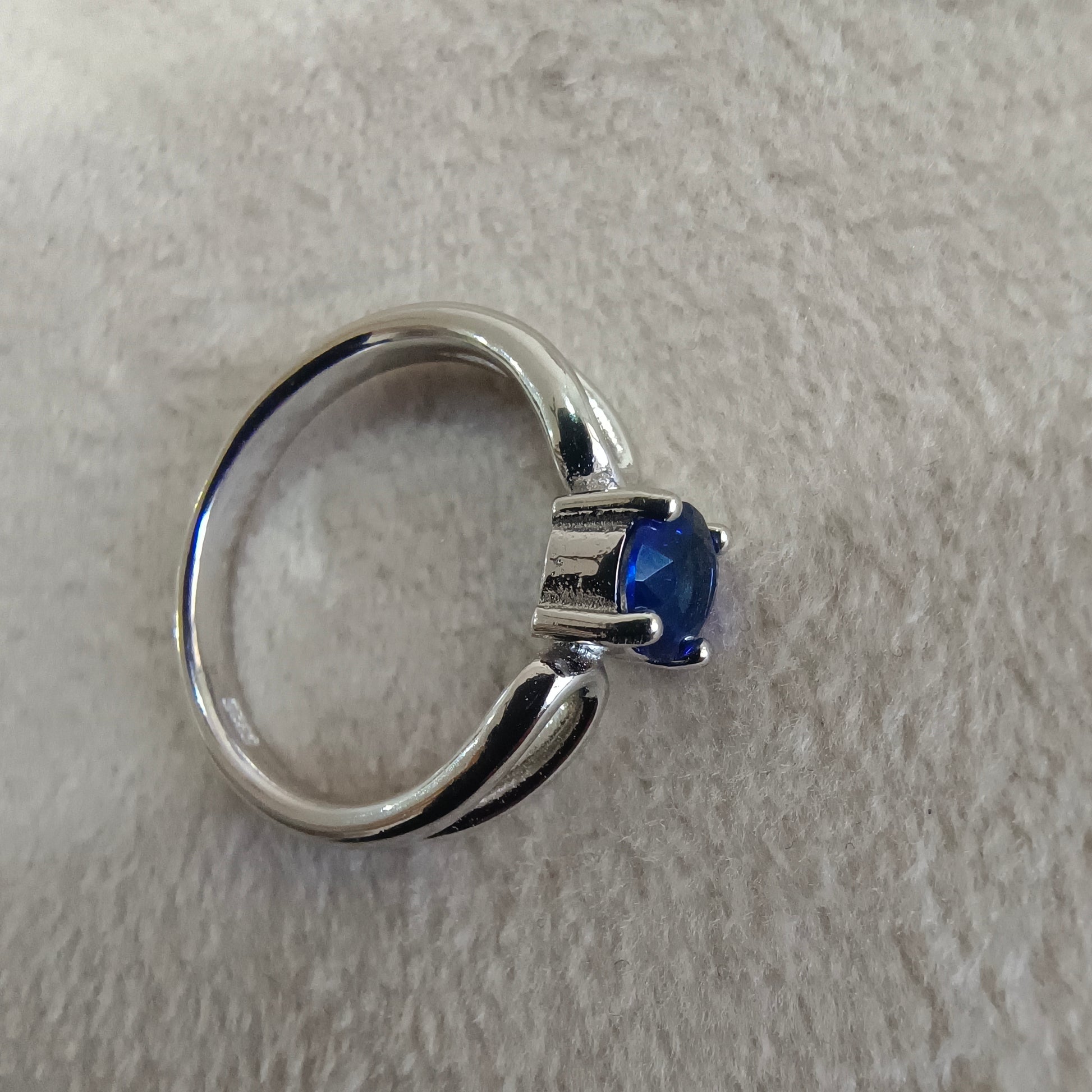 a silver ring with a blue stone on it