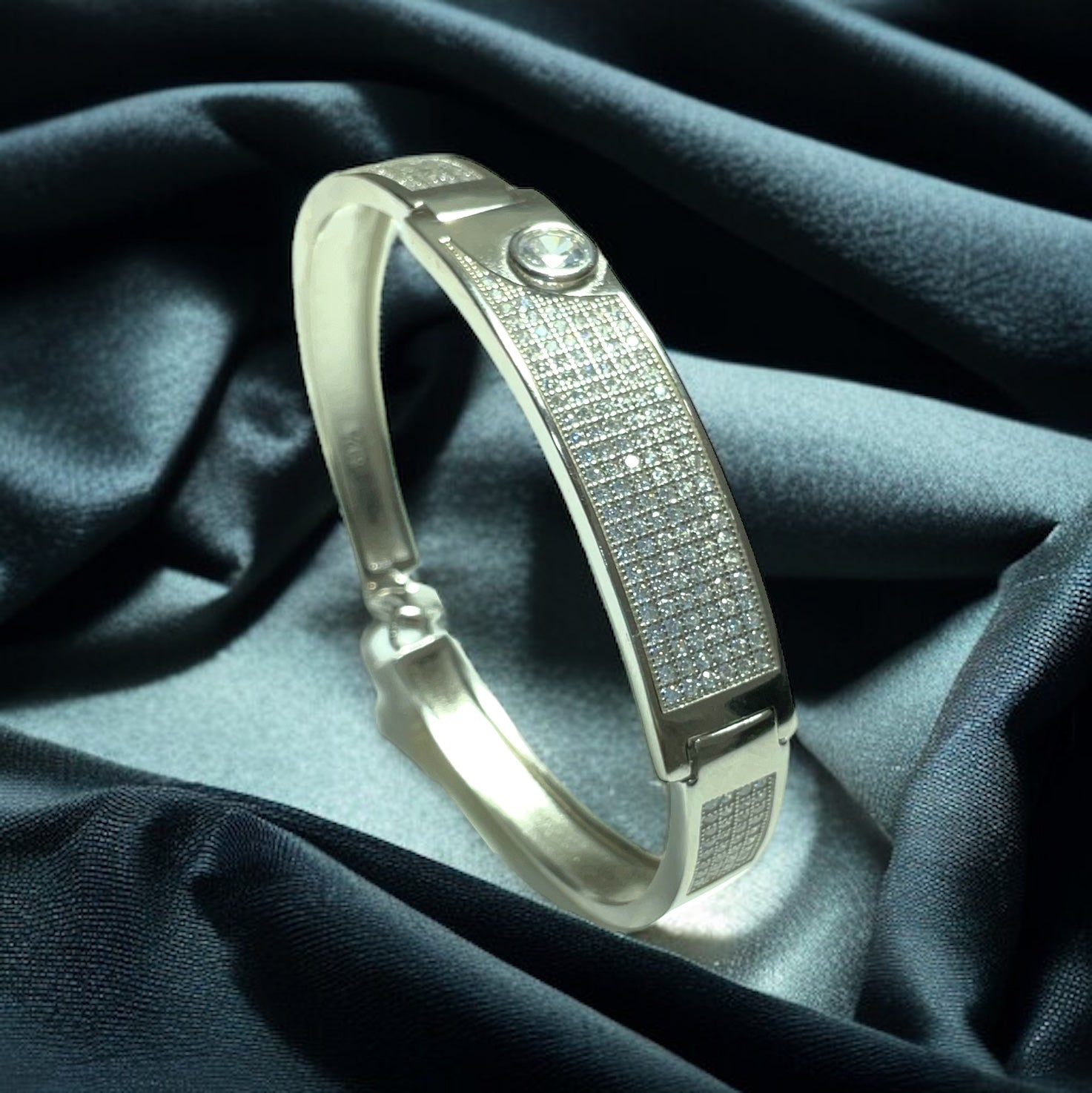 a gold bracelet with diamonds on a blue cloth