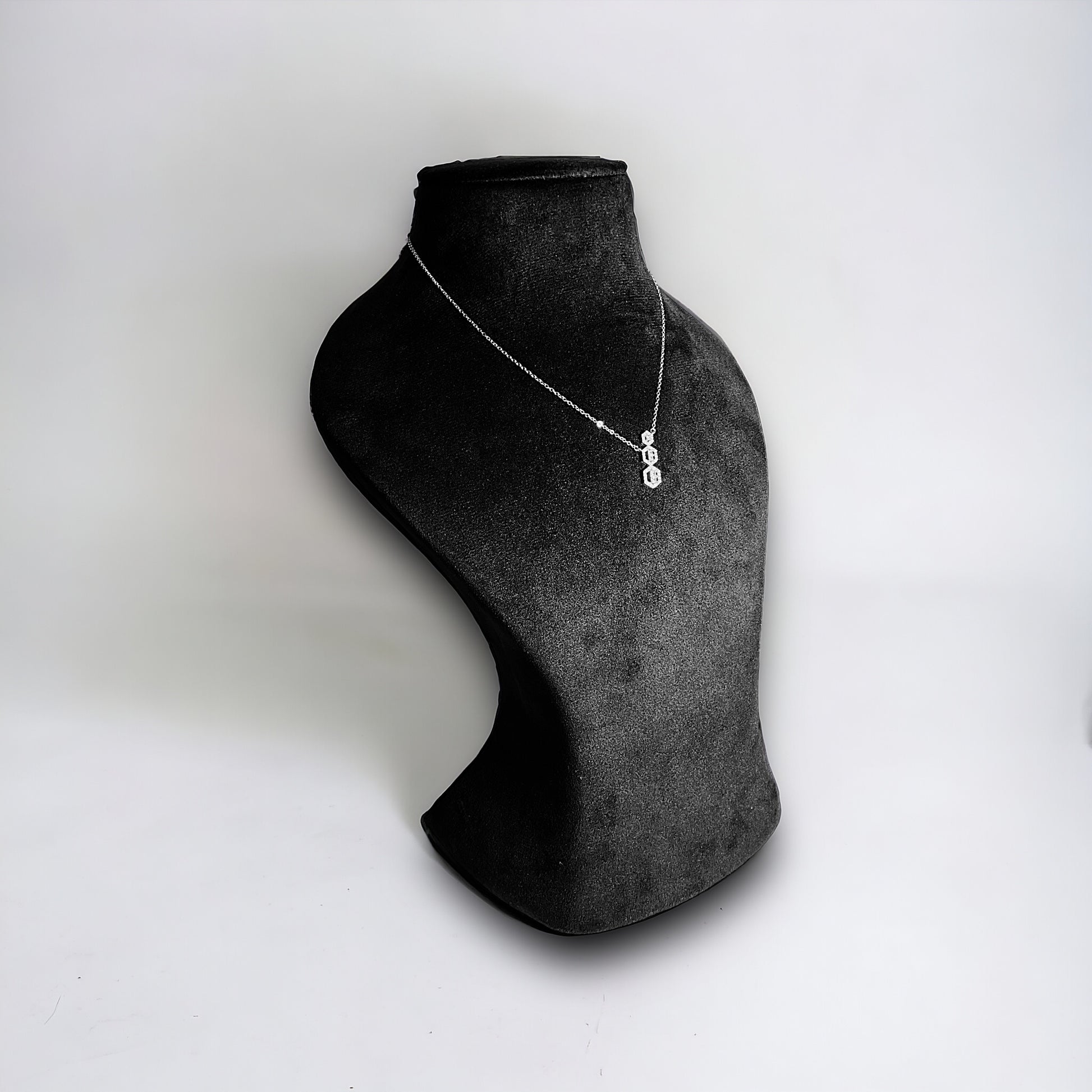 a black and white photo of a necklace on a mannequin